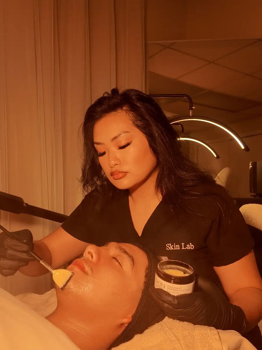 Esthetician applying a coconut papaya enzyme mask during a facial at Skin Lab in Memphis