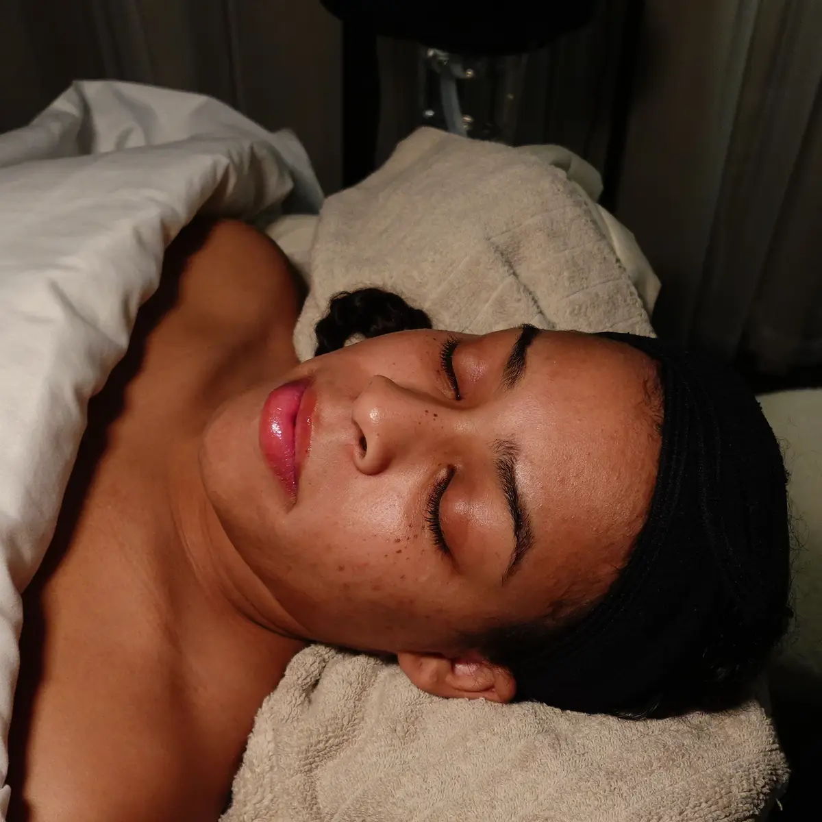 Esthetician assessing a client's skin before a Lymphatic Drainage Facial in Memphis